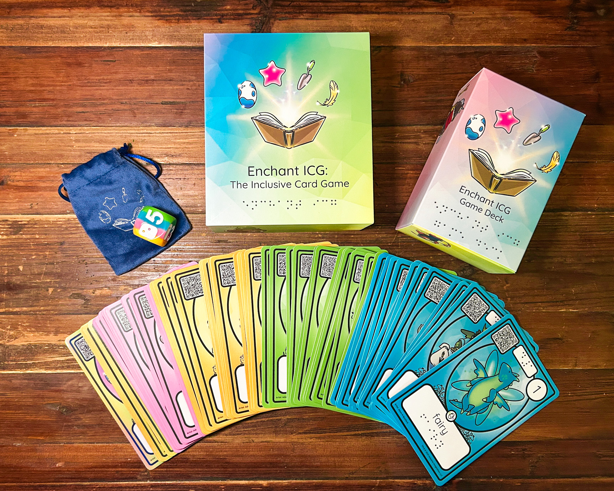 Enchant ICG Box Contents Array featuring box, cards, and d6.